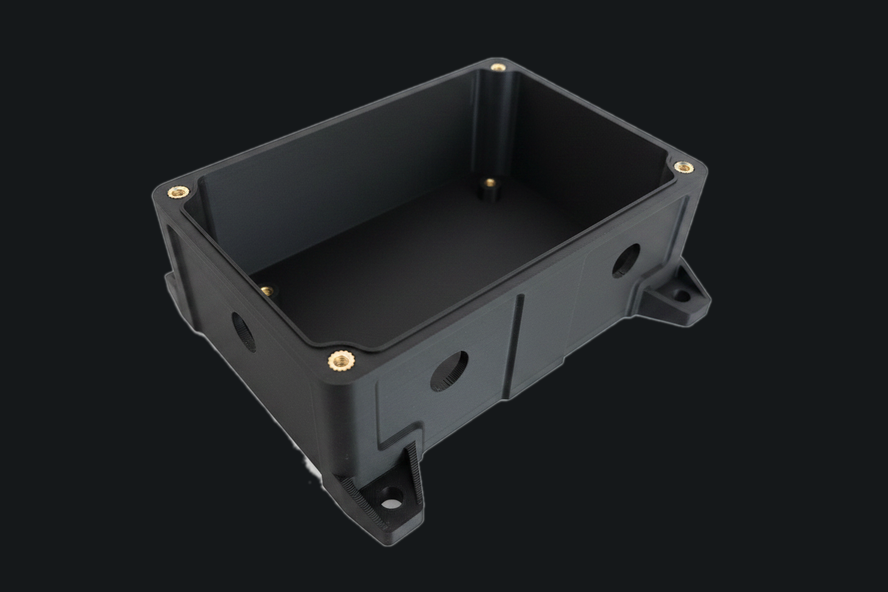 Electronics enclosure base open showing brass inserts