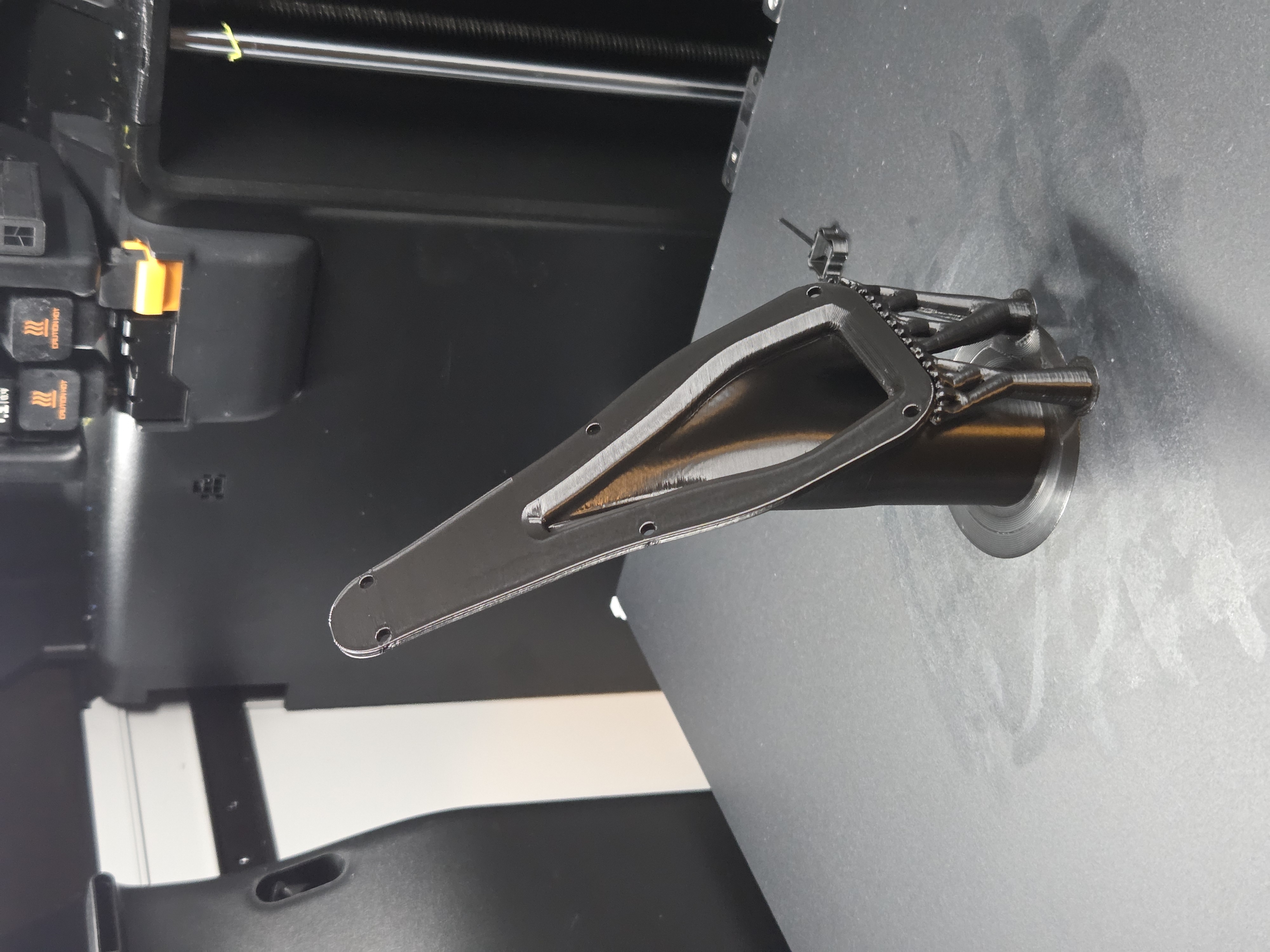 Custom duct part mid-print on a Bambu H2D printer build plate with tree supports visible